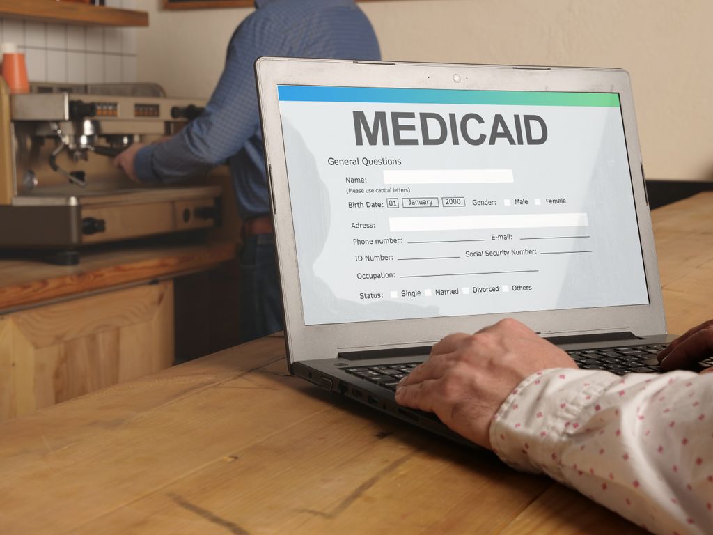 A person looks up Medicaid forms on a laptop. Medicaid reimbursement rates for mental health treatment varies by as much as five times, depending on the state where people live, according to new research from Oregon Health & Science University. (Getty Images)