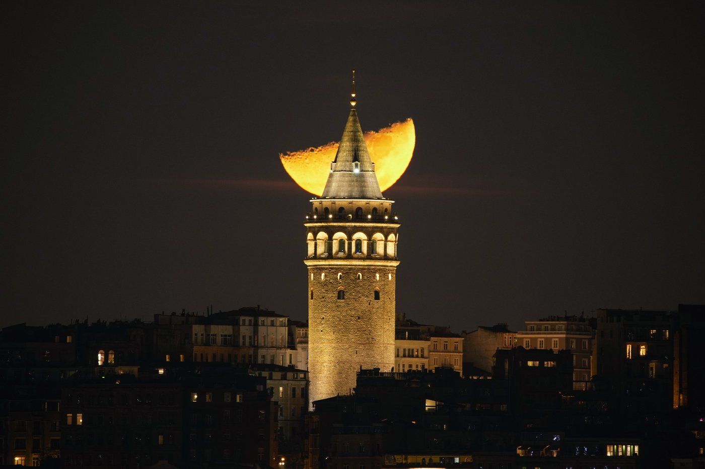 A half moon sets behind the Galata Tower in Istanbul, Tuesday, Jan. 7, 2025. (AP Photo/Emrah Gurel)